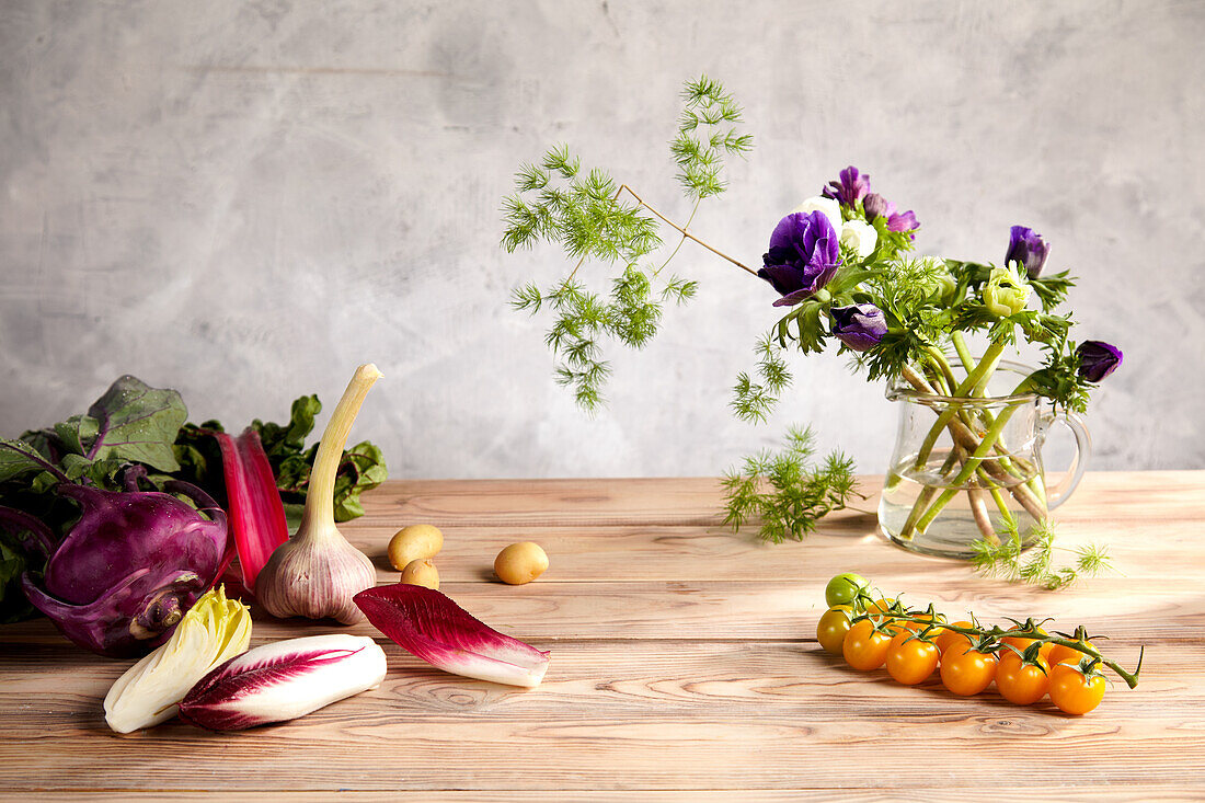 Stillleben mit frischem Gemüse und Blumen in Vase
