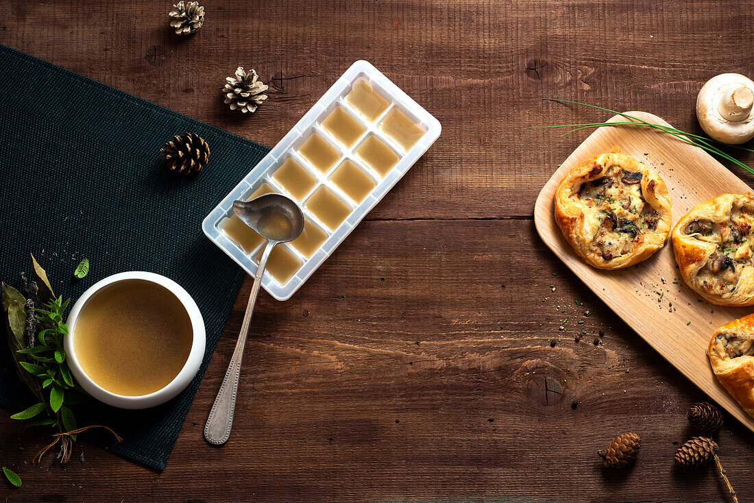 Mushroom tartlets next to clear broth filled ice cube tray