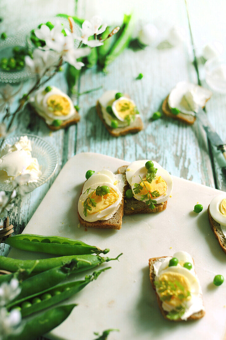 Slices of bread with hard-boiled egg and peas