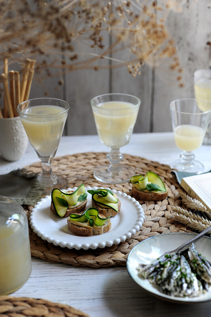 Pastis and toast with hummus and zucchini strips