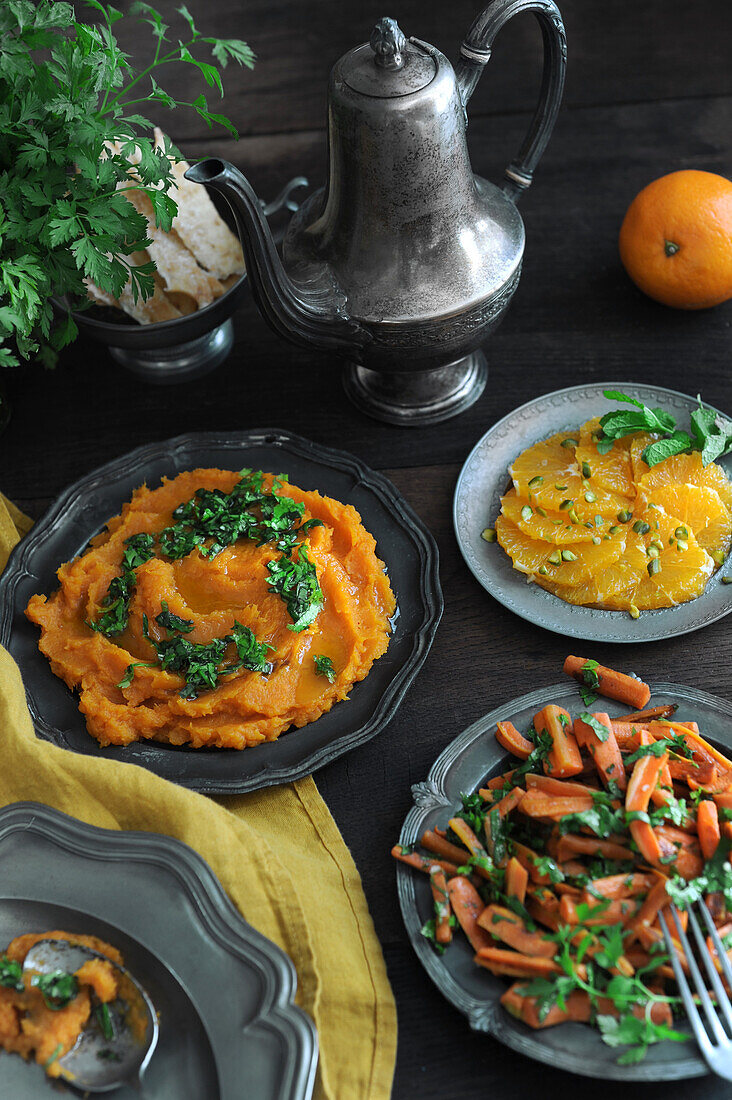 Orientalisches Buffet mit Karotten und Süßkartoffelpüree und Orangen