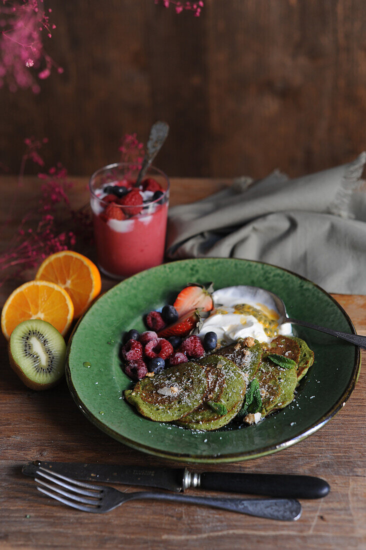 Sweet spinach pancakes with passion fruit curd and berries