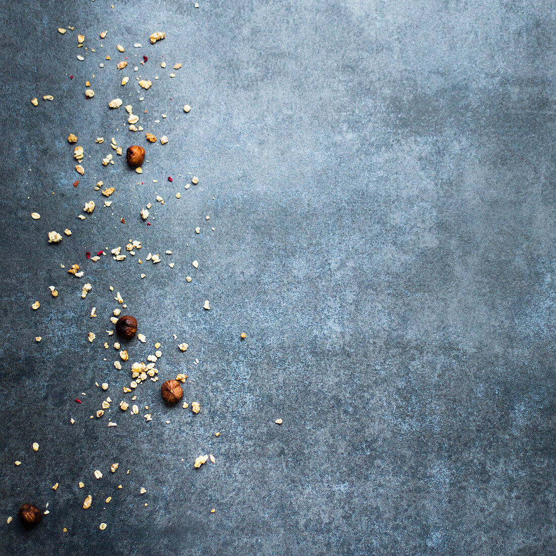 Hazelnuts and crumbs on a blue-grey background