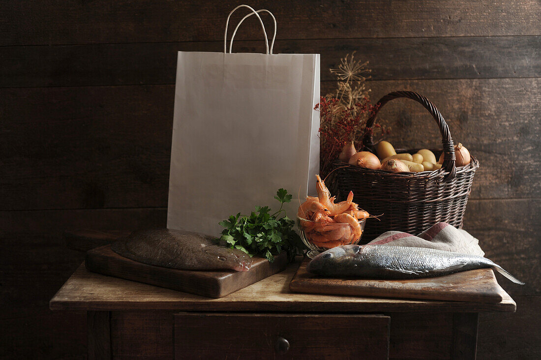 Still life with fish, shrimp, basket of potatoes, onions and parsley