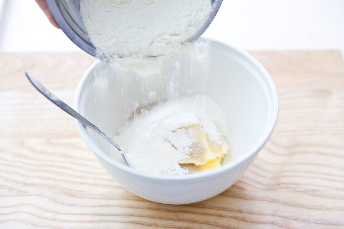 Aprikosen-Crumble zubereiten: Für die Streusel Mehl zur Butter geben