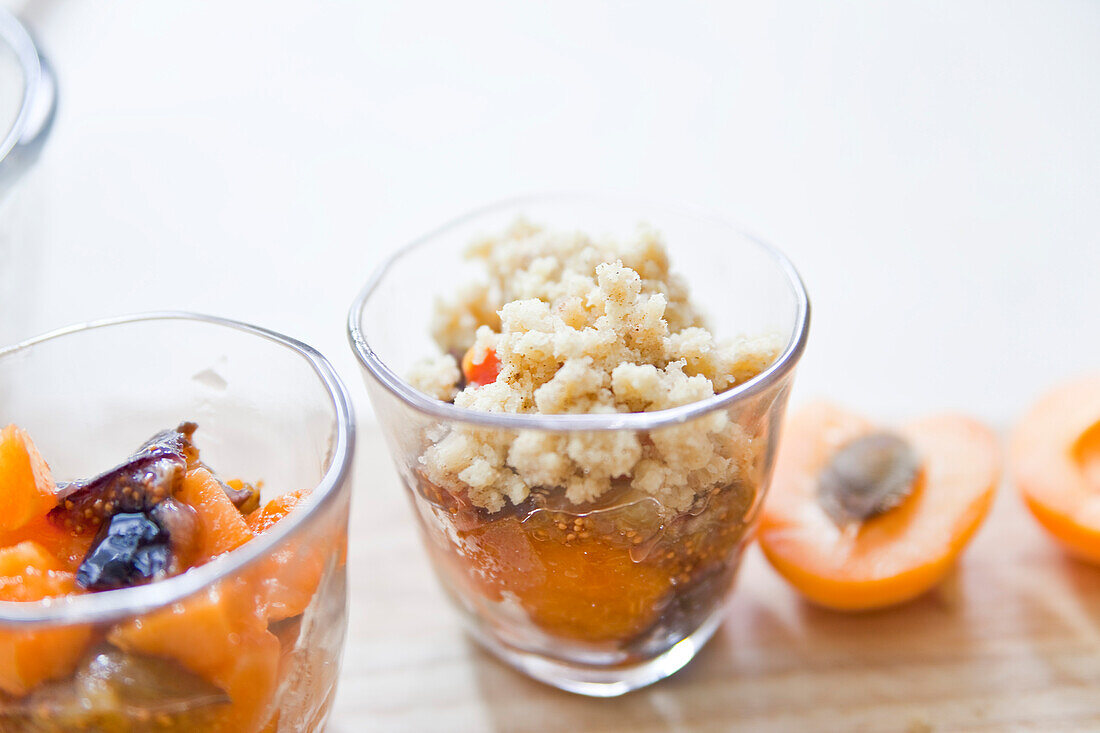 Preparing apricot crumble: layering ingredients in dessert glasses