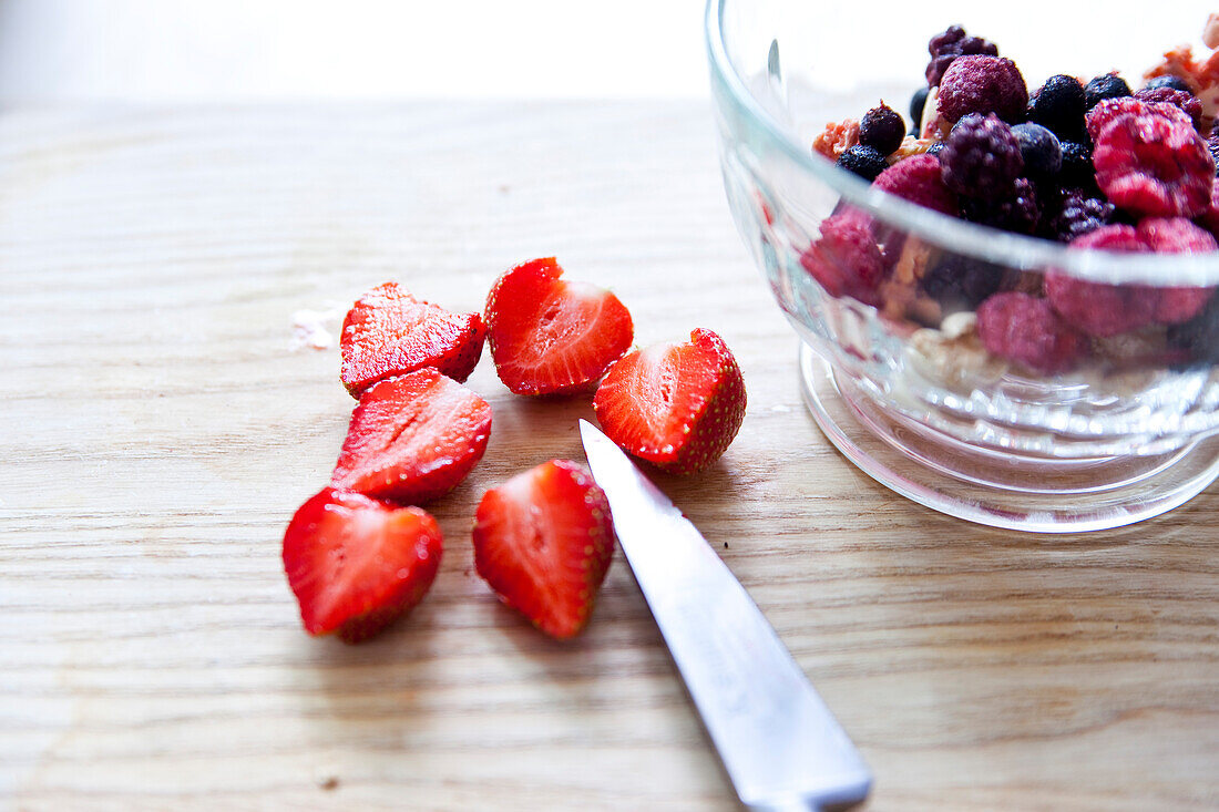 Preparing a berry bowl with macaron crumbs