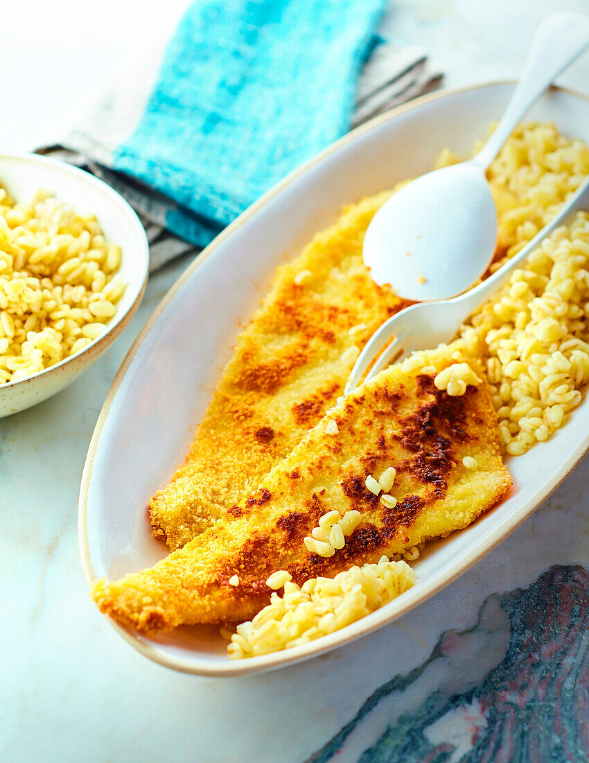 Breaded fish fillets served with small pasta