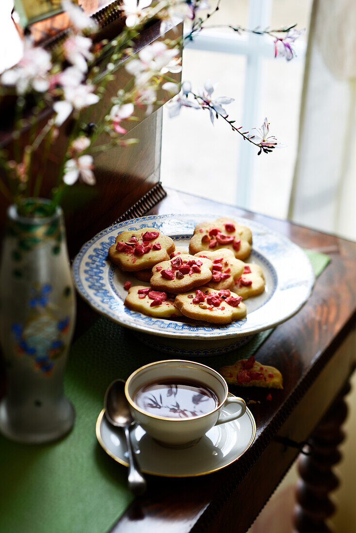 Shortbread biscuits decorated with praline roses, served with tea