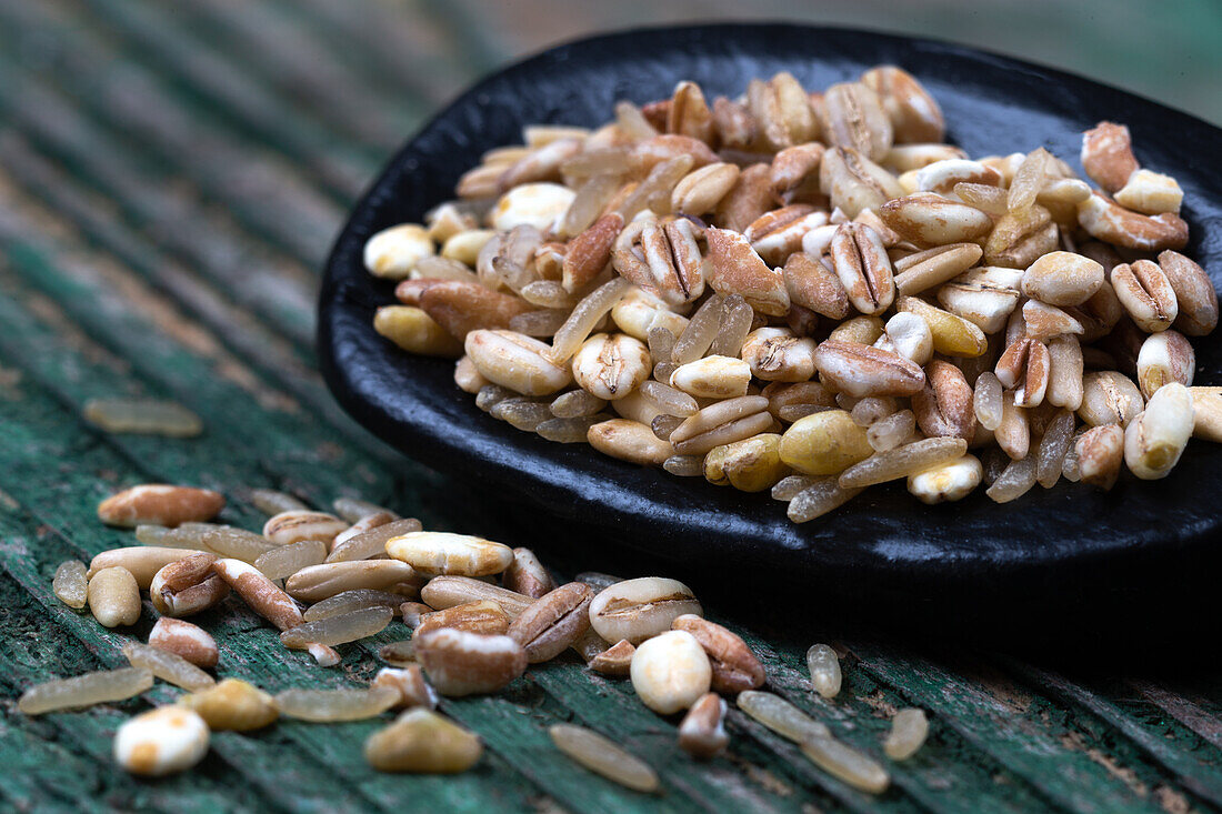 Mixture of spelt, barley, wheat, oats, and rice on spoon (close-up)