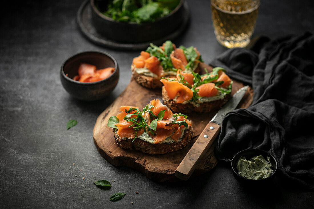 Toasted slices of bread with herb butter and smoked trout