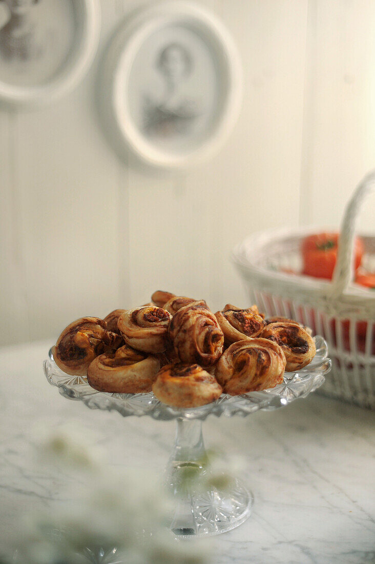 Small puff pastry snails with tomatoes in the background