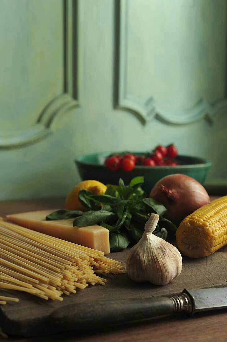 Zutaten für Spaghetti mit Knoblauch, Tomate, Zwiebel, Basilikum, Mais und Zitrone
