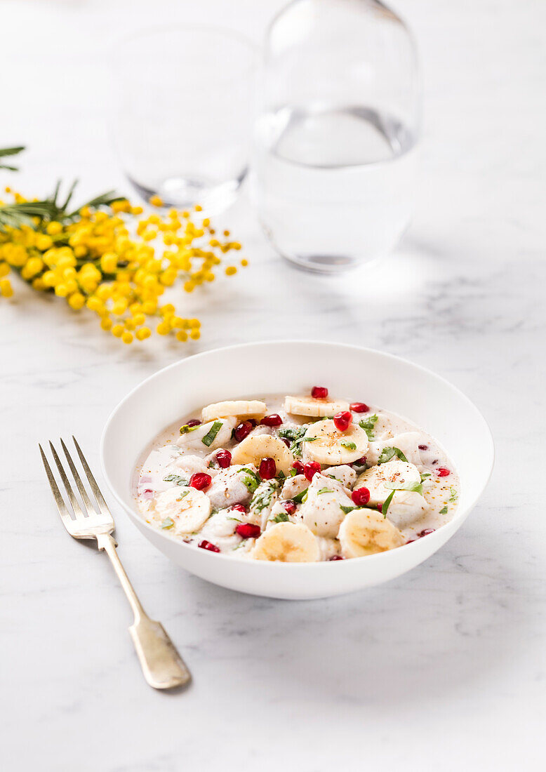 White fish ceviche with banana and pomegranate seeds