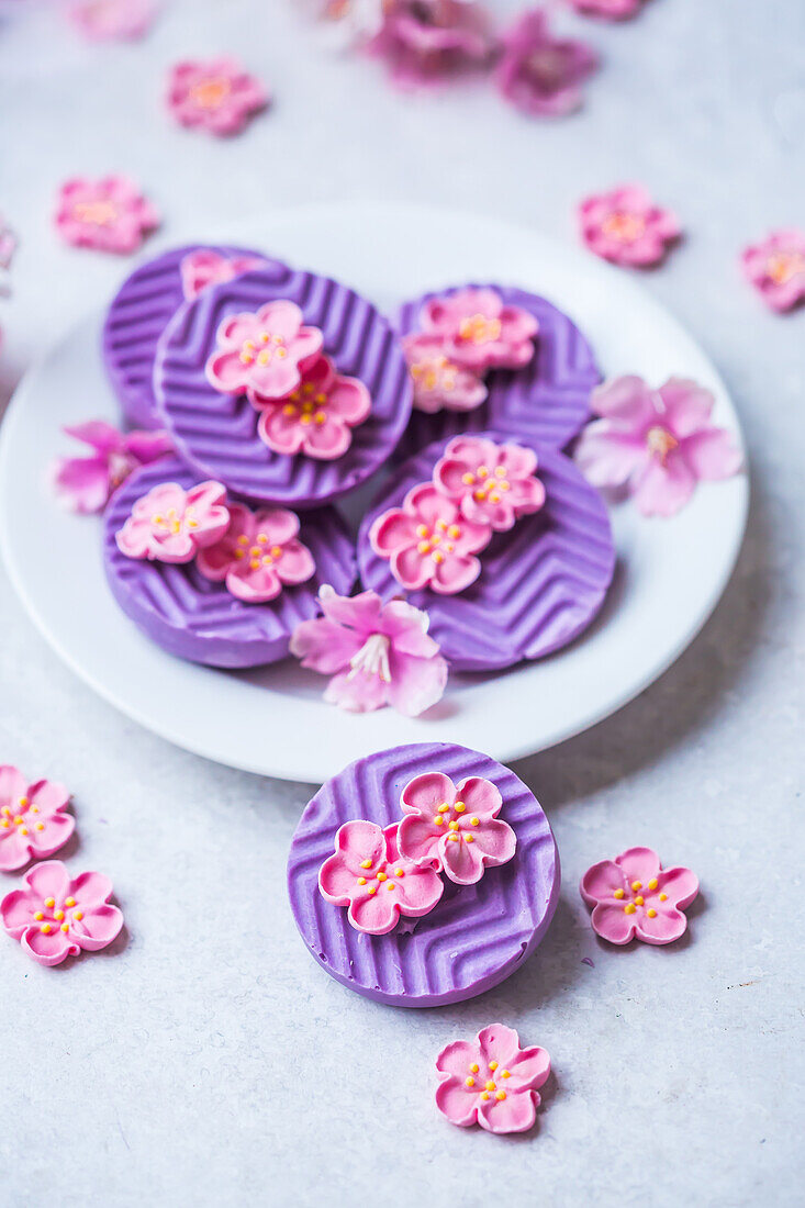 Violette Schokoladentaler mit Blütengeschmack und Blütenverzierung