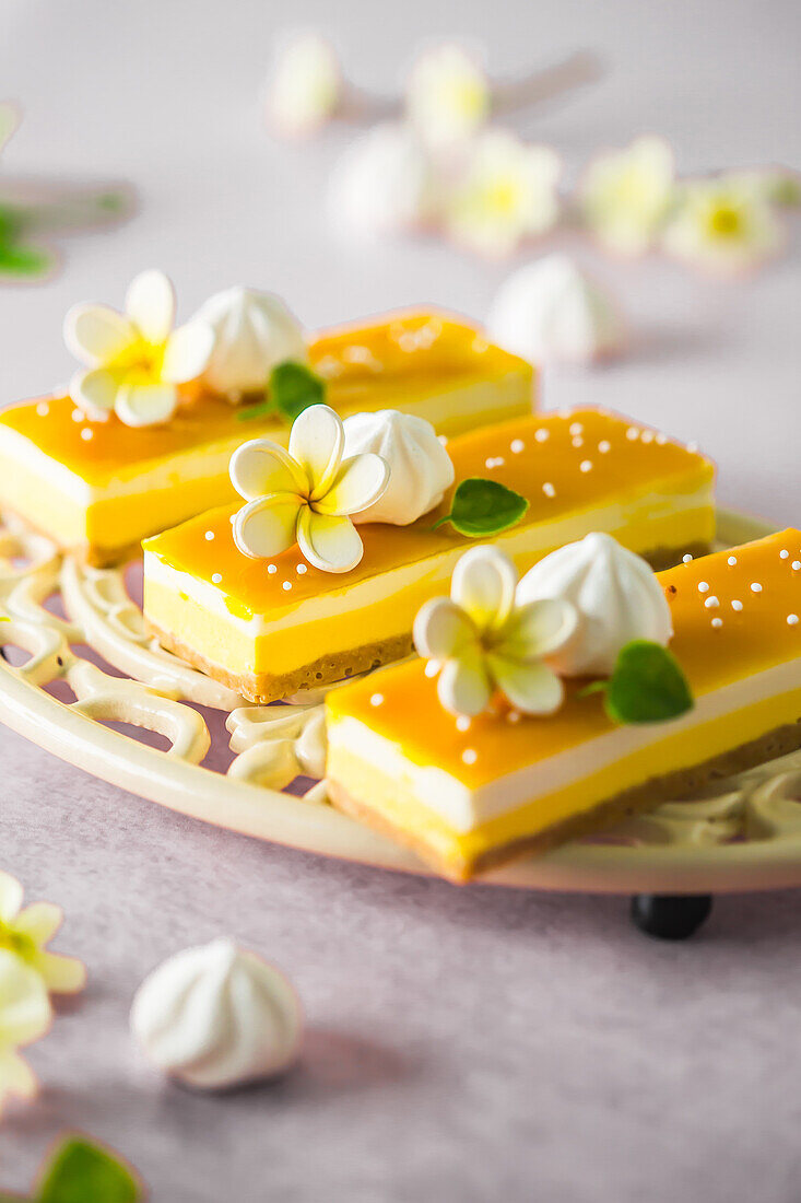 No-bake mango slices decorated with coconut foam and sugar blossom