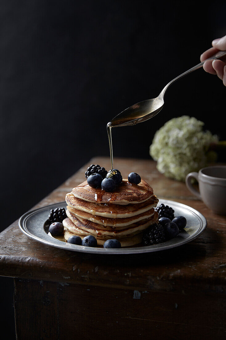 Stack of Pancakes with blueberries, blackberries and honey