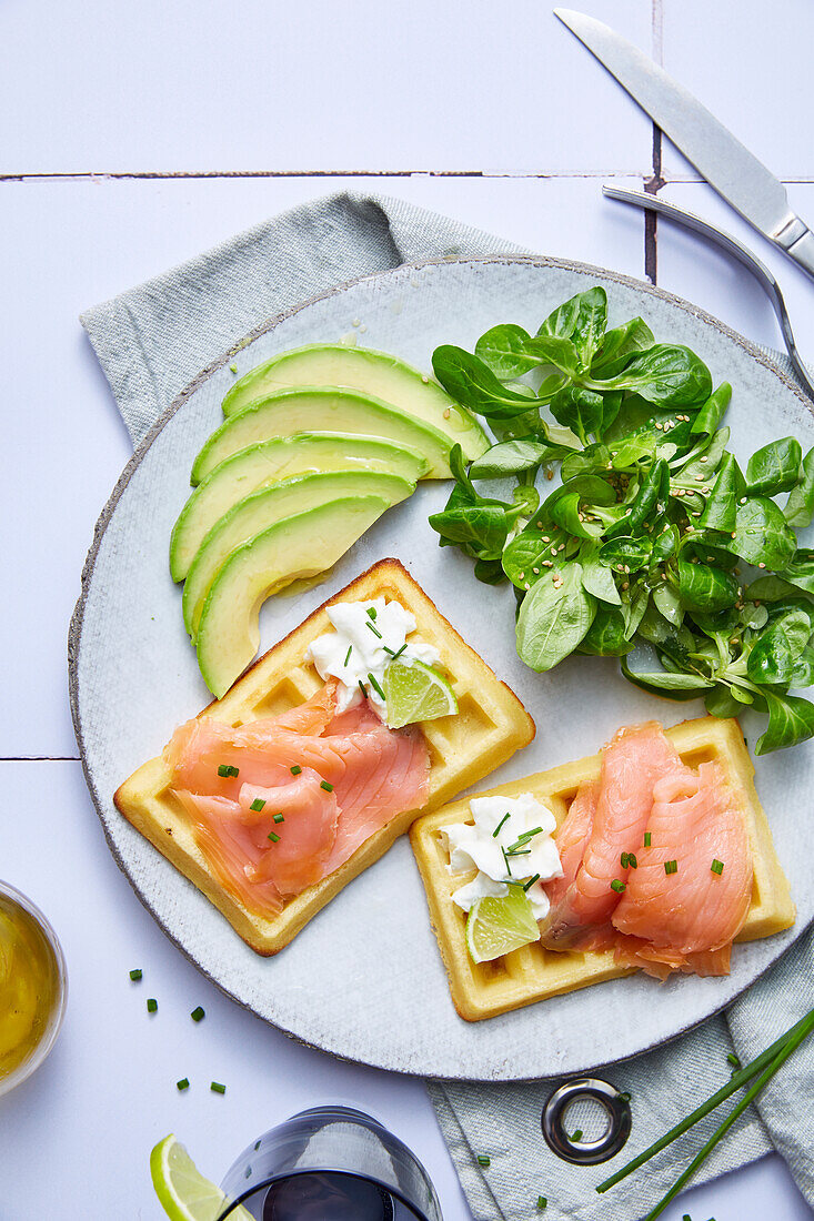 Waffles garnished with smoked salmon,avocado and salty whipped cream