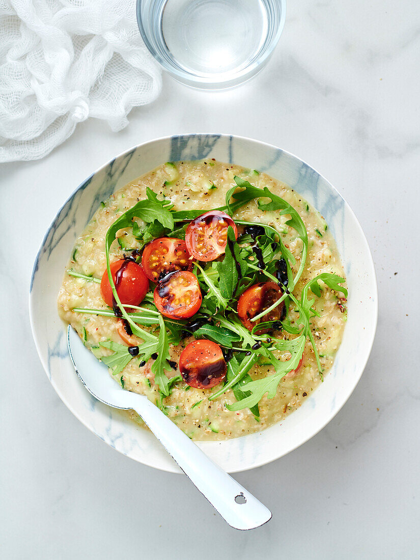 Porridge with zucchini, cherry tomatoes and rocket