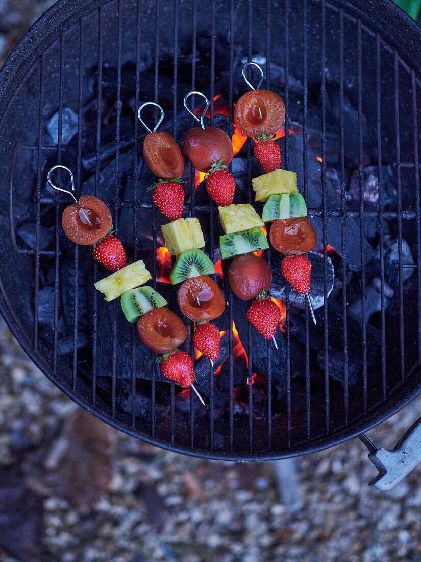 Fruit brochettes cooking on the barbecue