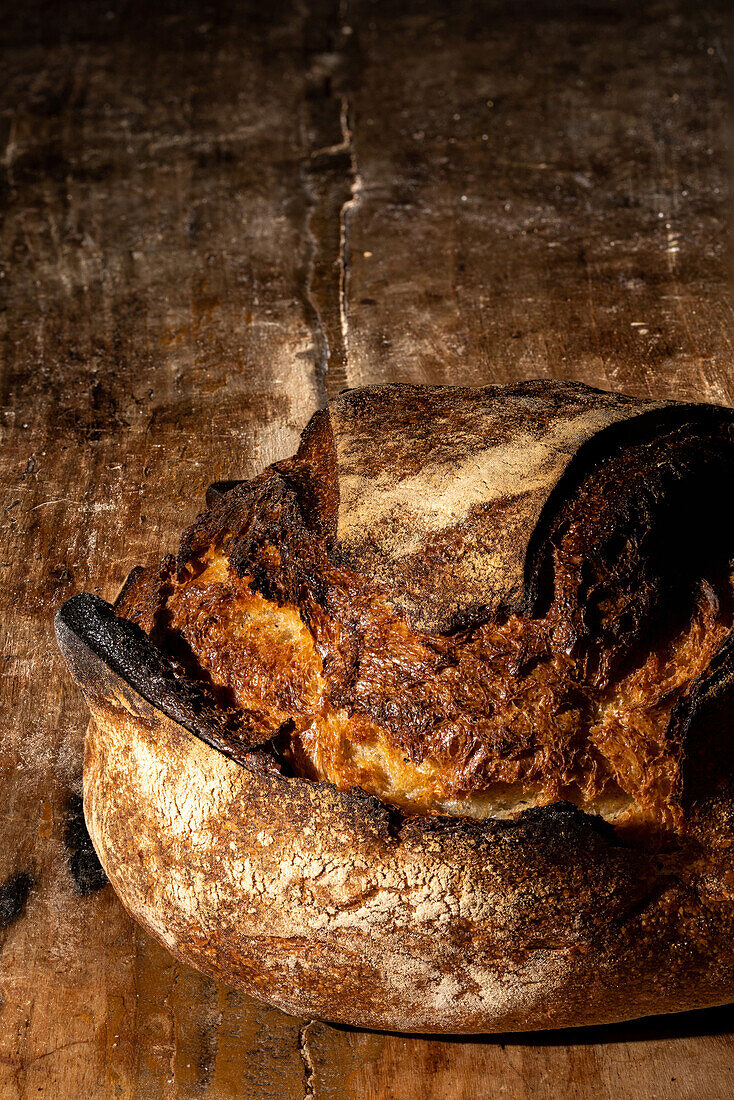 Rustikaler Brotlaib auf Holztisch