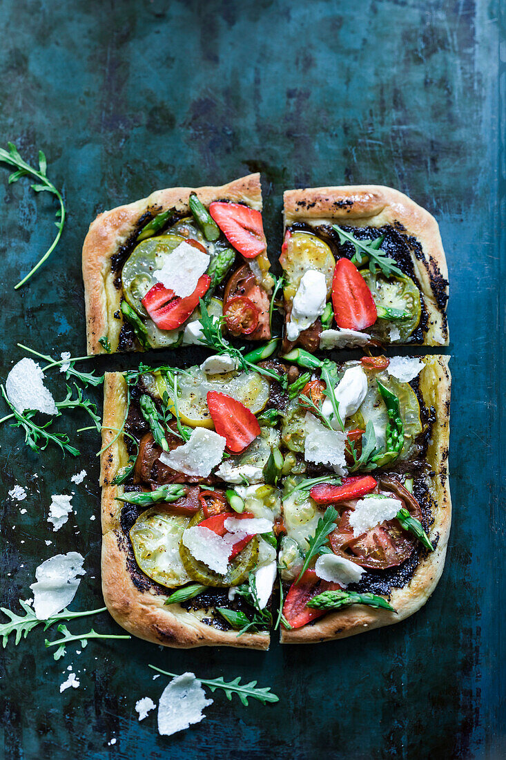 Pizza mit Tapenade, Tomaten, Erdbeeren und Parmesan