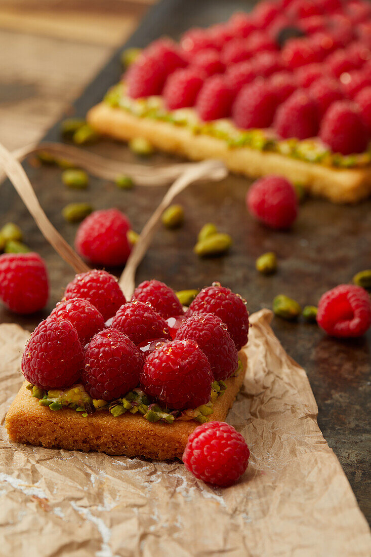 Quadratisches Mürbeteig-Törtchen mit Himbeeren und Pistazien