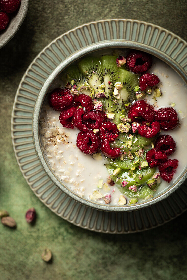 Porridge mit Haferflocken, Kiwi, Pistazien und Himbeeren