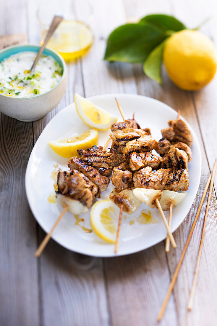 Pork filet mignon skewers marinated with garlic and lemon served with tzatziki