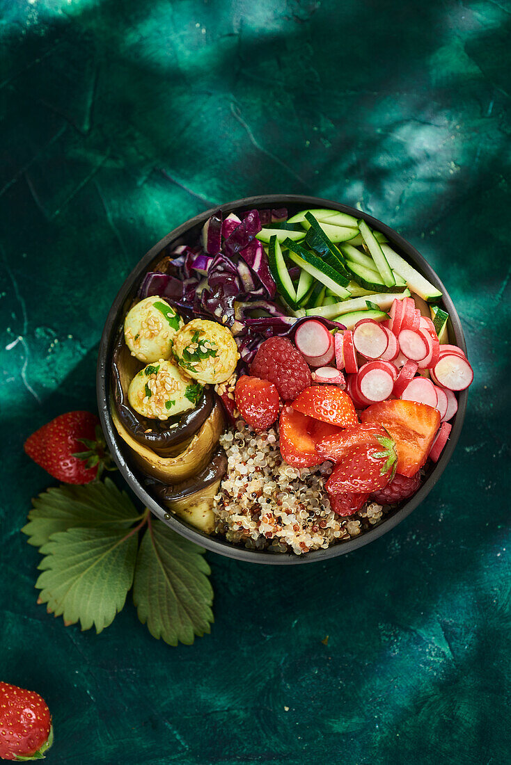 Buddha Bowl with quinoa, strawberries, radishes, courgettes, red cabbage and aubergines