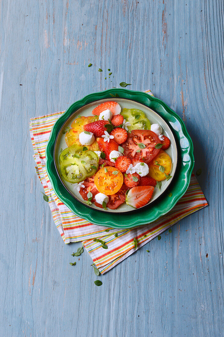 Colourful tomato salad with mini mozzarella and strawberries