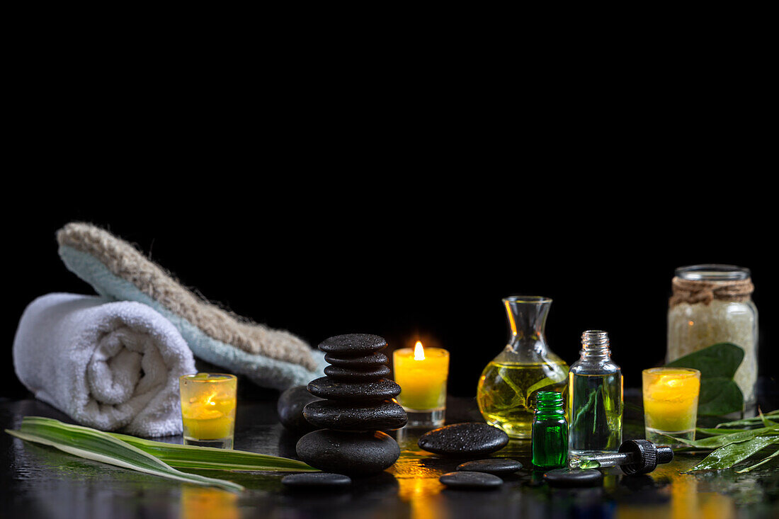 Hot stones, essential oils, towel, horsehair glove and candles for a beauty ritual
