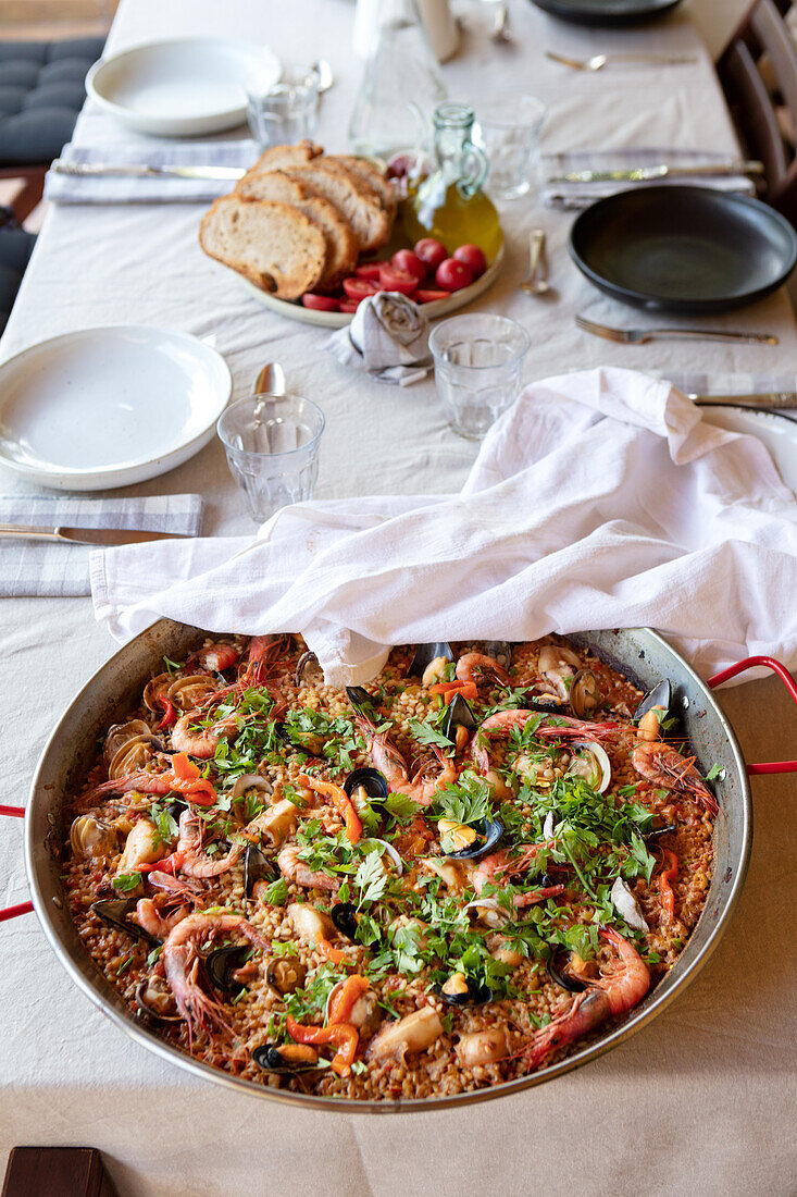 Homemade paella in a pan on a set table