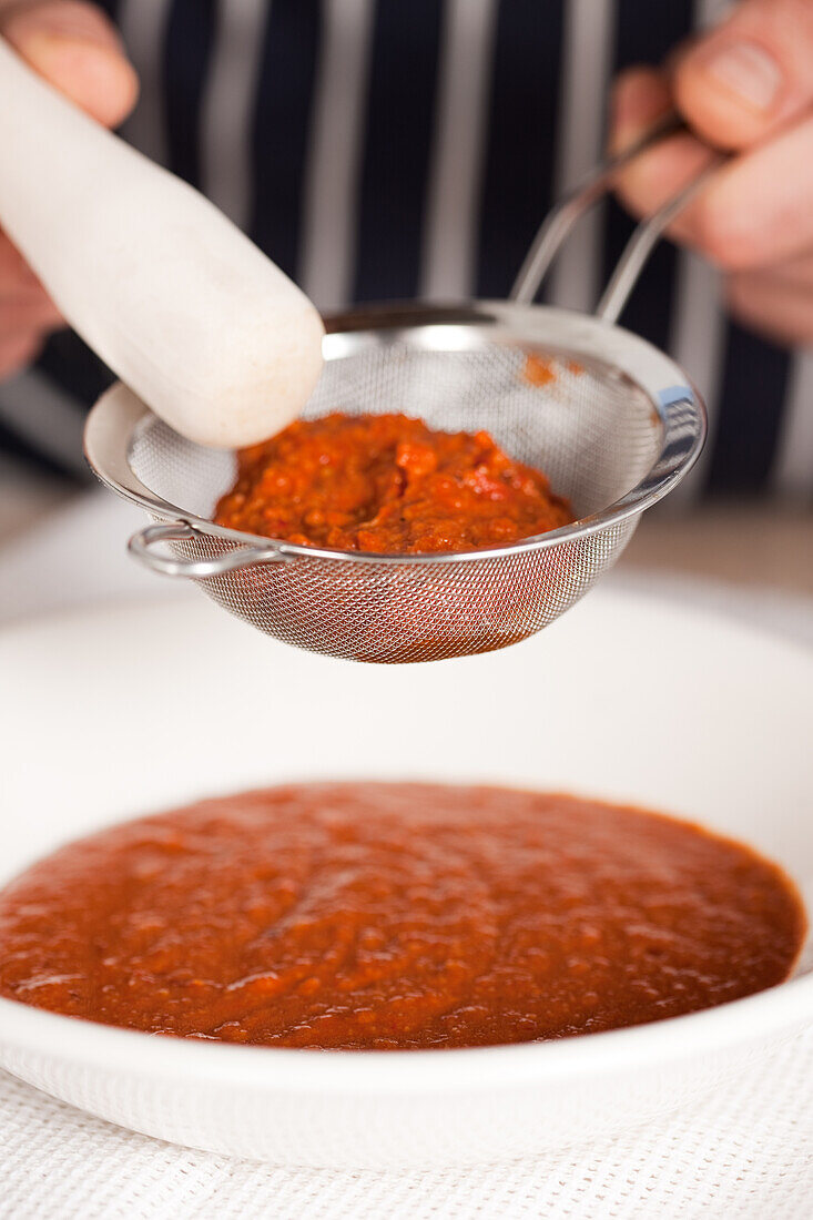 Zubereitung einer Romanesco-Sauce - Sauce durch Sieb passieren