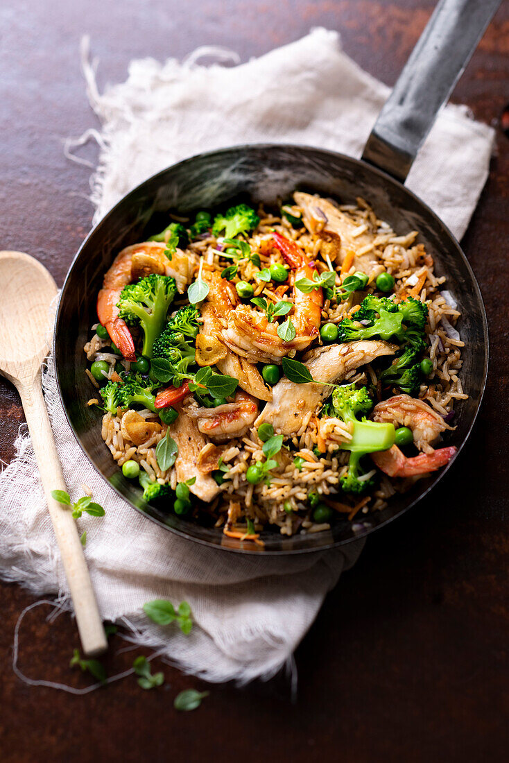 Fried rice with chicken, prawns and vegetables cooked in a wok