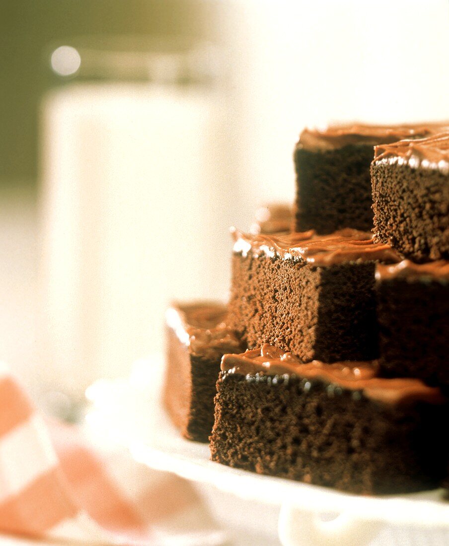 Brownies auf Kuchenplatte, im Hintergrund ein Glas Milch