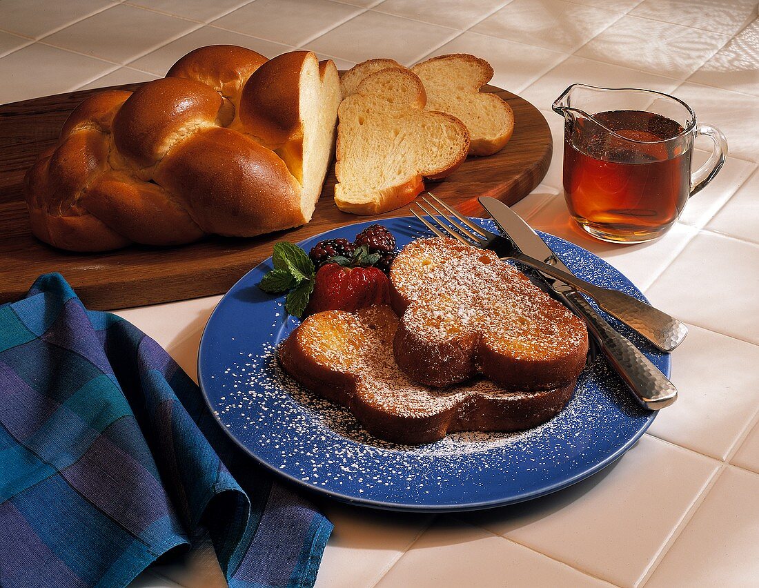 French Toast with Powdered Sugar and Berrie; Egg Bread and Pitcher of Maple Syrup