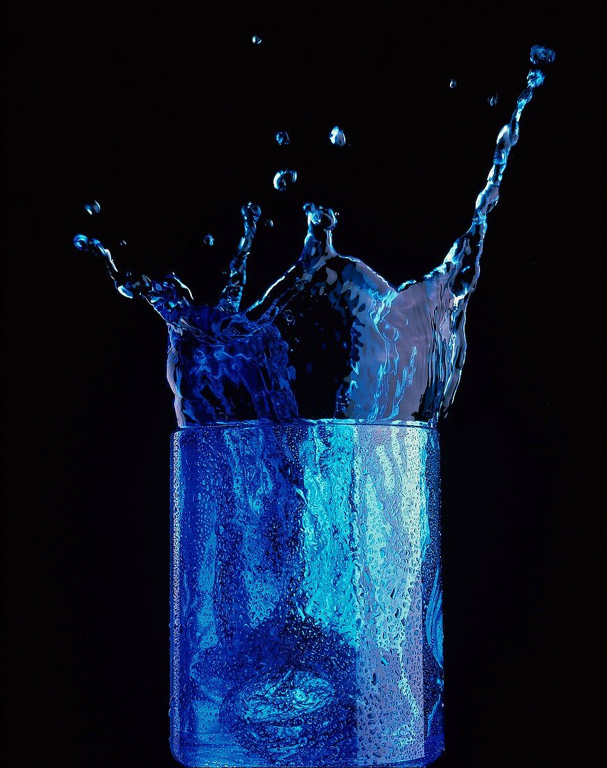 Blue Splash (blau gefärbtes Getränk spritzt aus Glas)