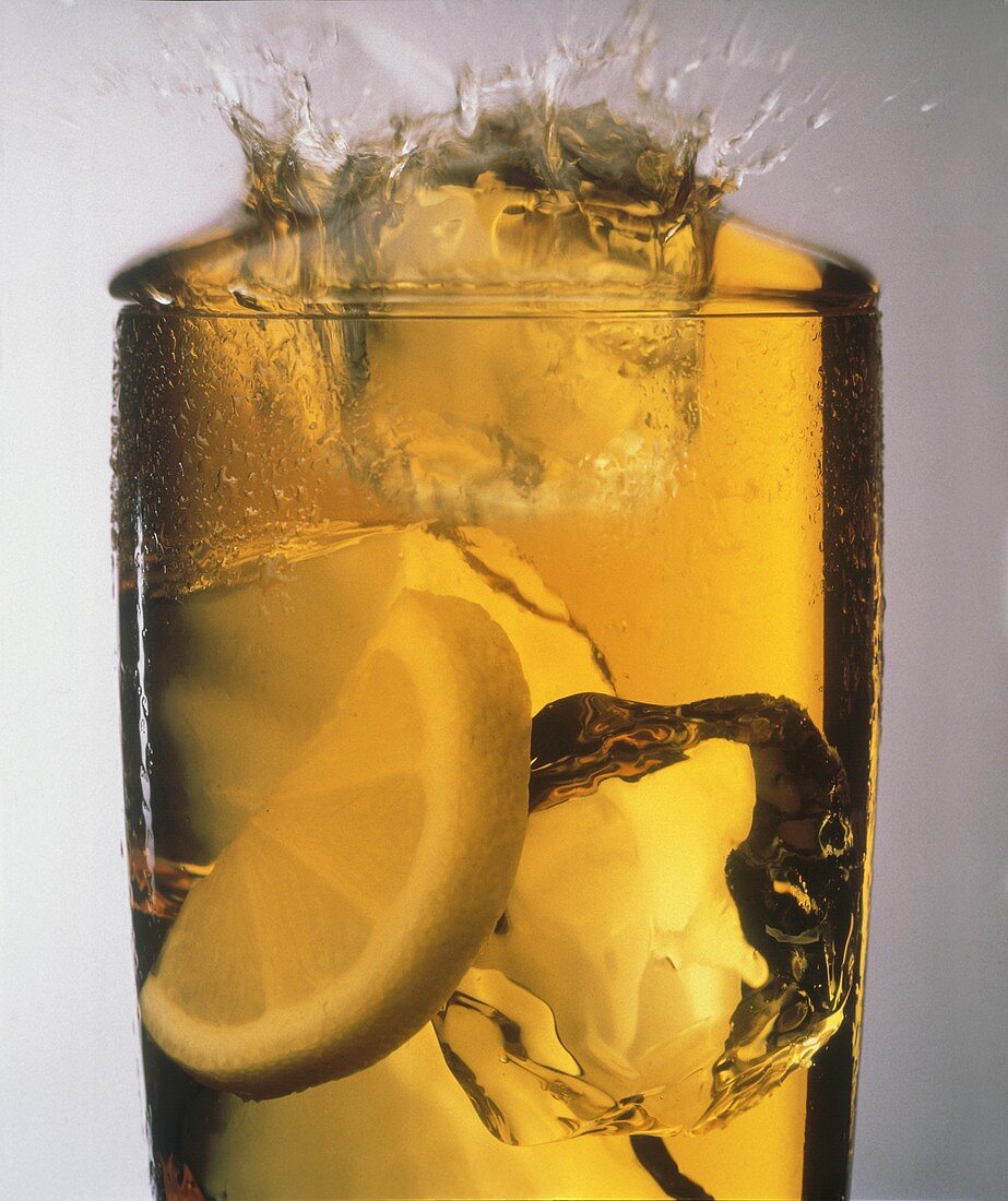 Ice Cube Splashing into a Glass of Iced Tea