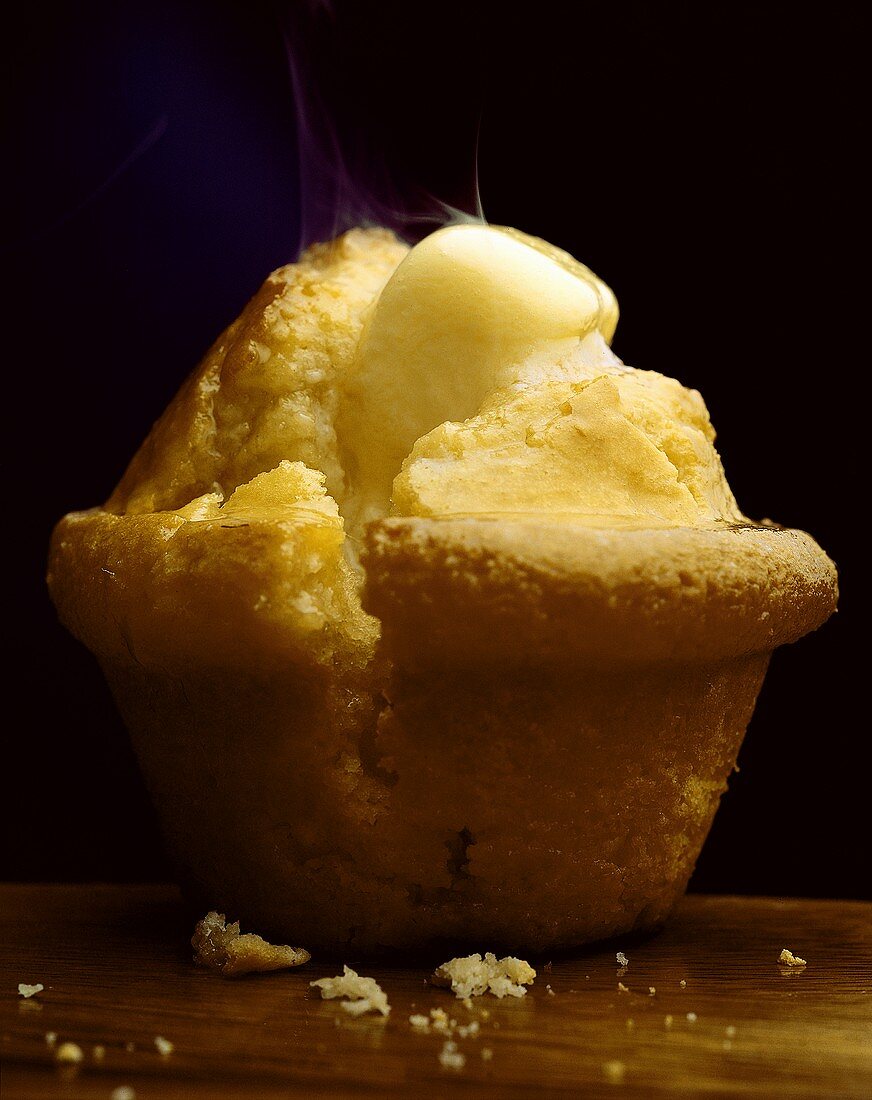 Ein Polenta-Muffin mit schmelzender Butter