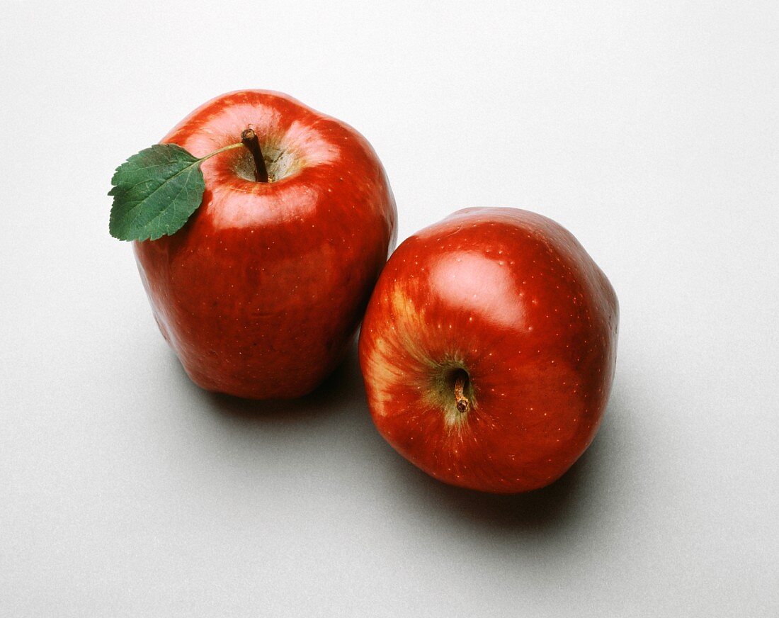 Zwei ganze Red Delicious Äpfel auf weißem Untergrund