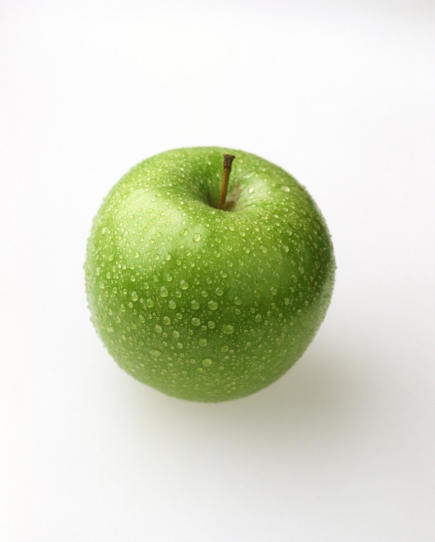 A Granny Smith apple with drops of water