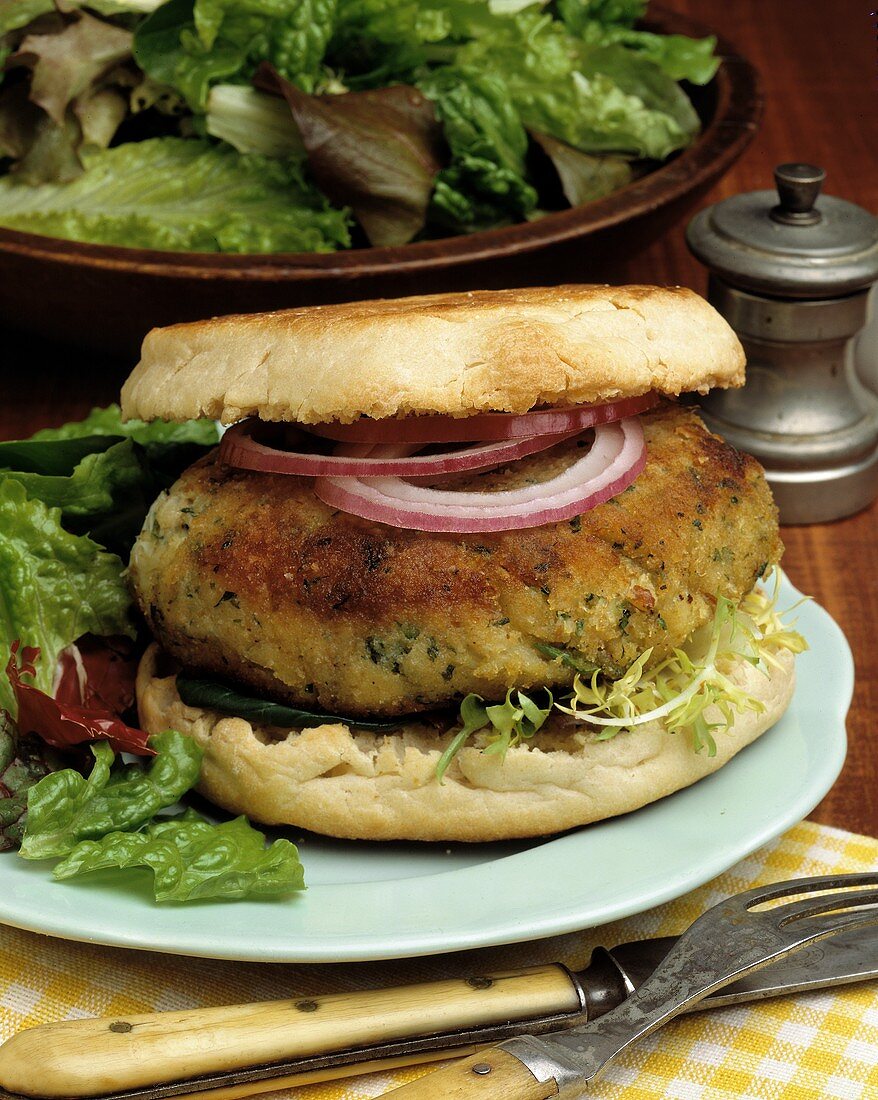 Vegetarischer Burger mit roten Zwiebelringen und Salat