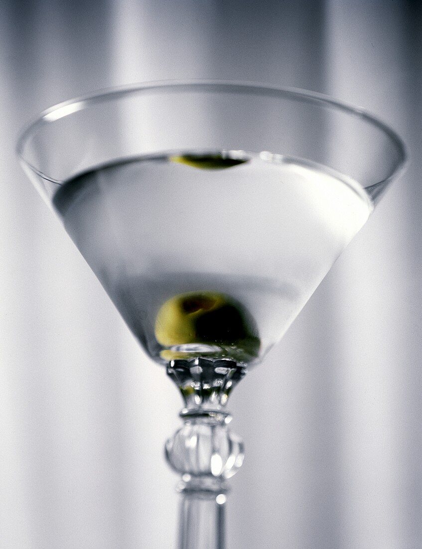 Ein Glas Martini mit grüner Olive (Nahaufnahme)