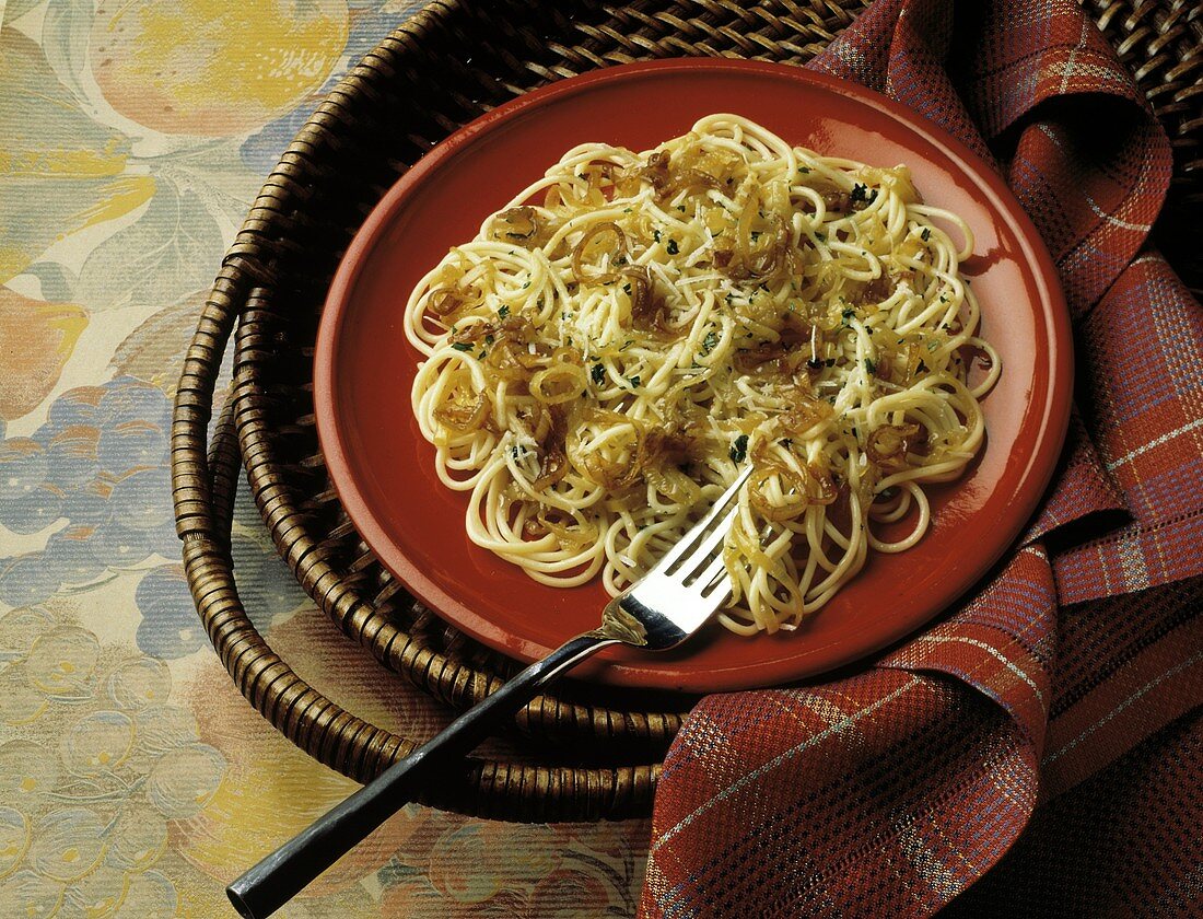 Spaghetti mit karamellisierten Zwiebeln auf rotem Teller