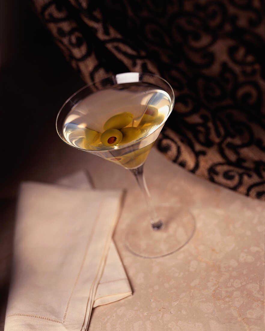Martini in einem Martiniglas mit grünen Oliven
