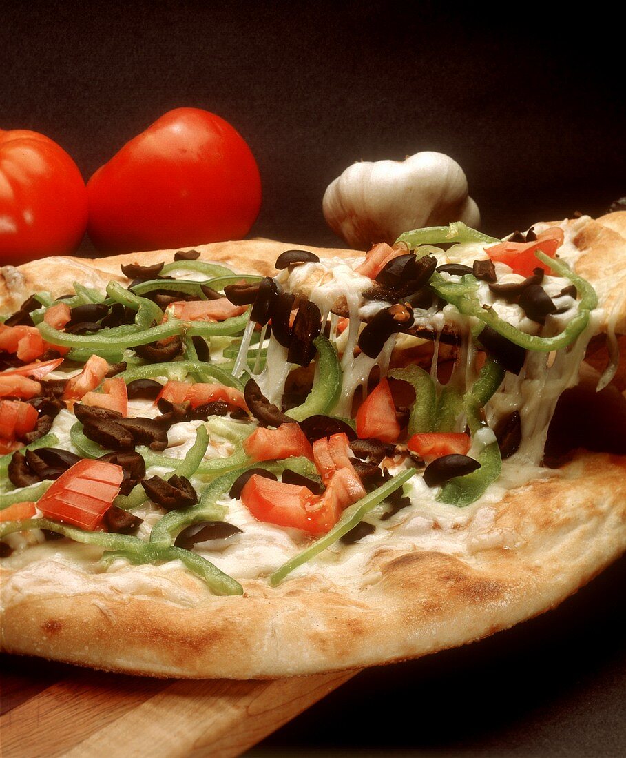 Gemüsepizza mit Paprika, Oliven & Käse, ein Stück angehoben