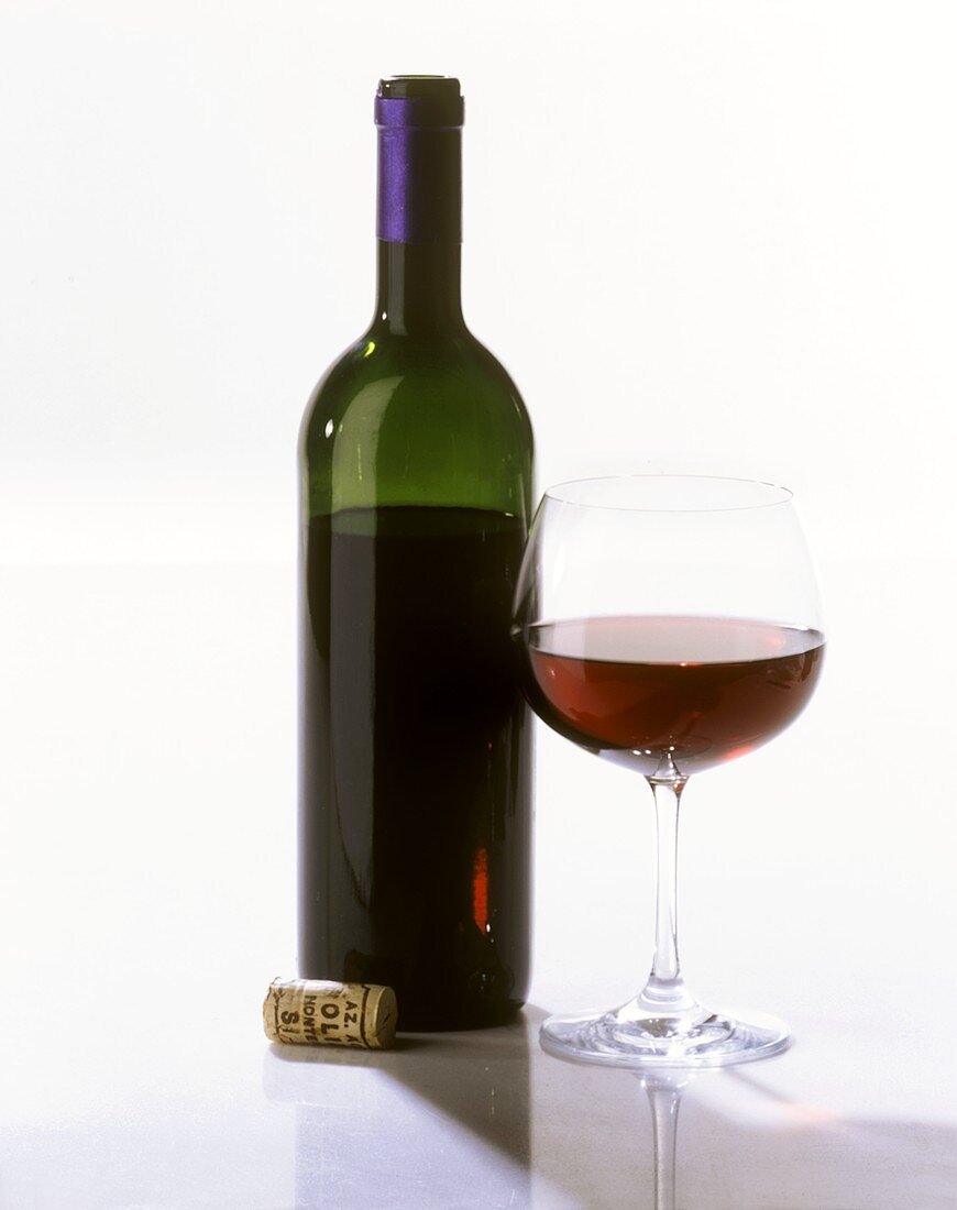 Eine Flasche (ohne Etikett) und ein Glas Rotwein, Korken