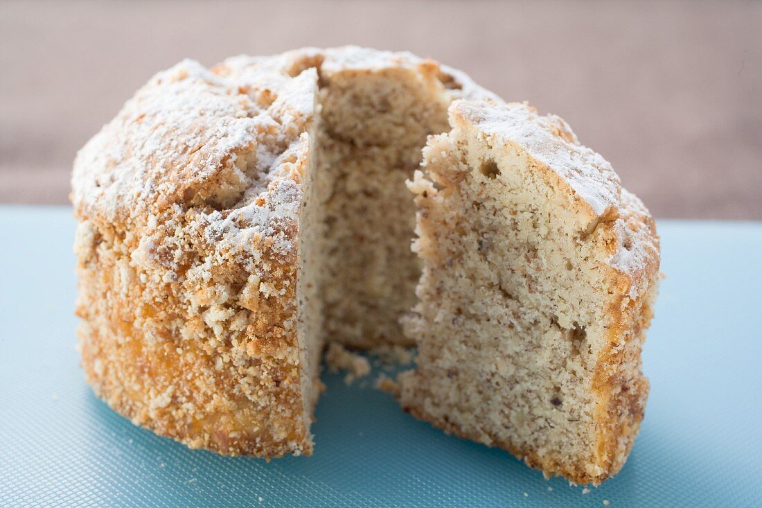 A cake dusted with icing sugar, sliced