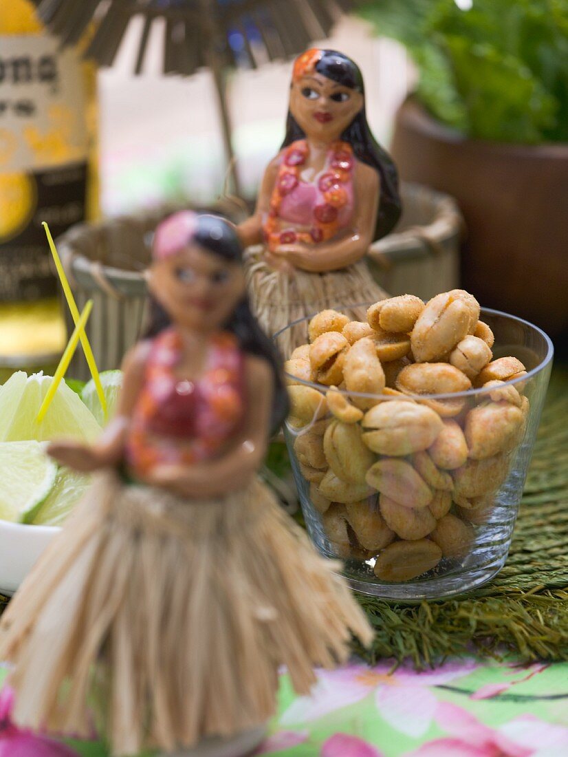 Salted peanuts in a glass on a table with Hawaiian decorations
